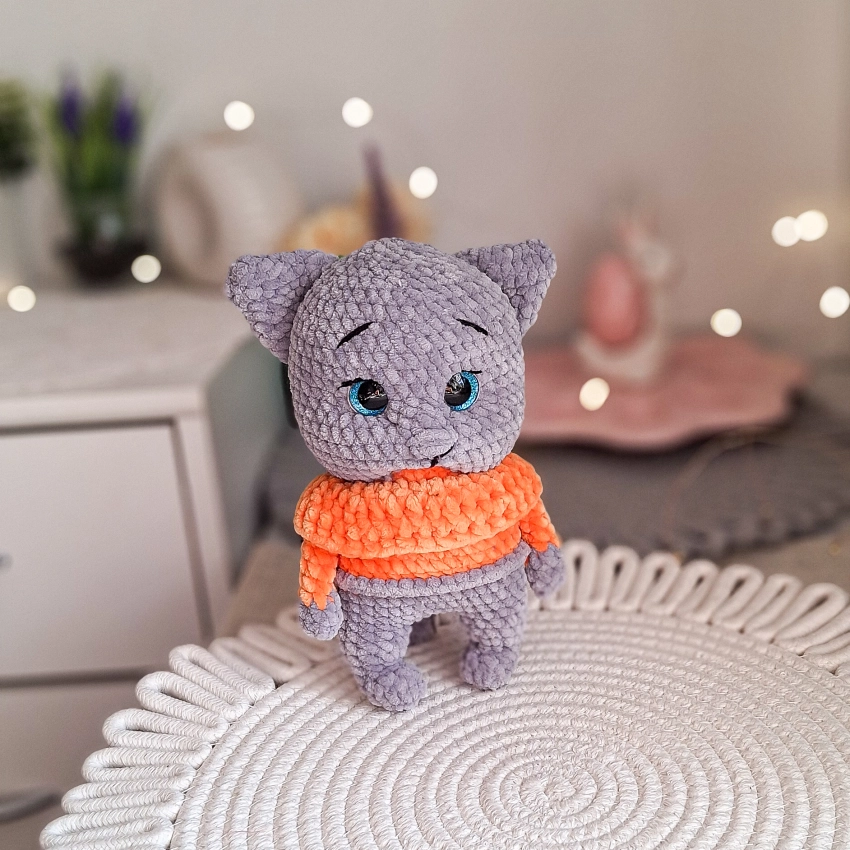 Handmade crochet grey cat wearing an orange sweater made from soft plush yarn.